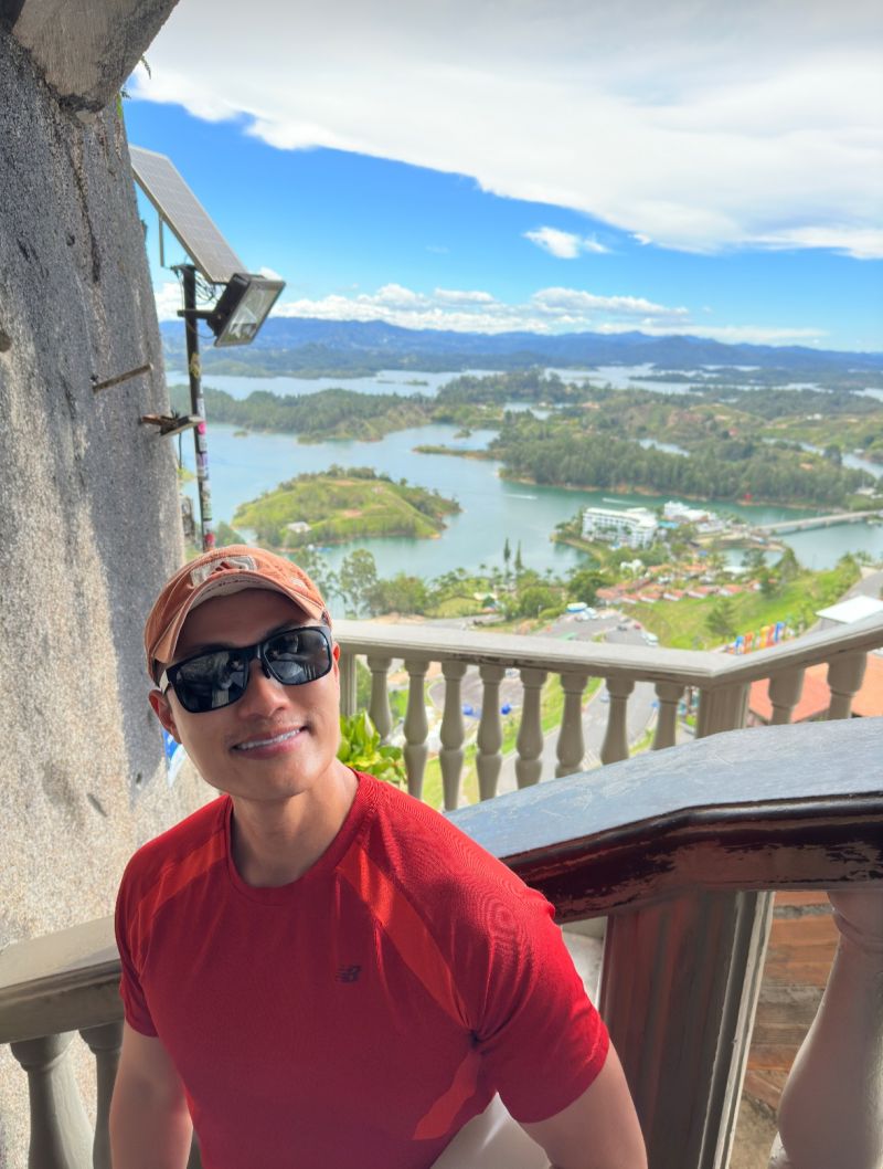David at a stone railing high above the green islands and lakes of Guatape, Colombia.
